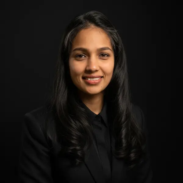 Person in black attire, dark background.