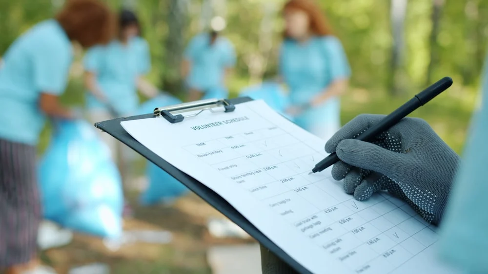 clinical trial seo Person in gloves writing on clipboard during cleanup event.