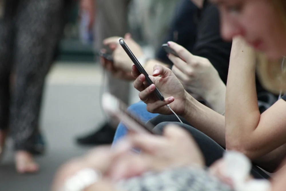 Person holding a phone checking social media notifications