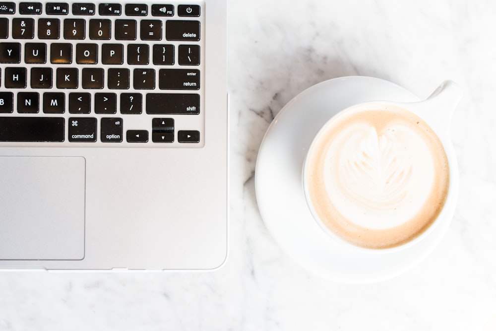 Clover SEO Services for Restaurants 27 cappuccino on teacup and coaster beside a MacBook