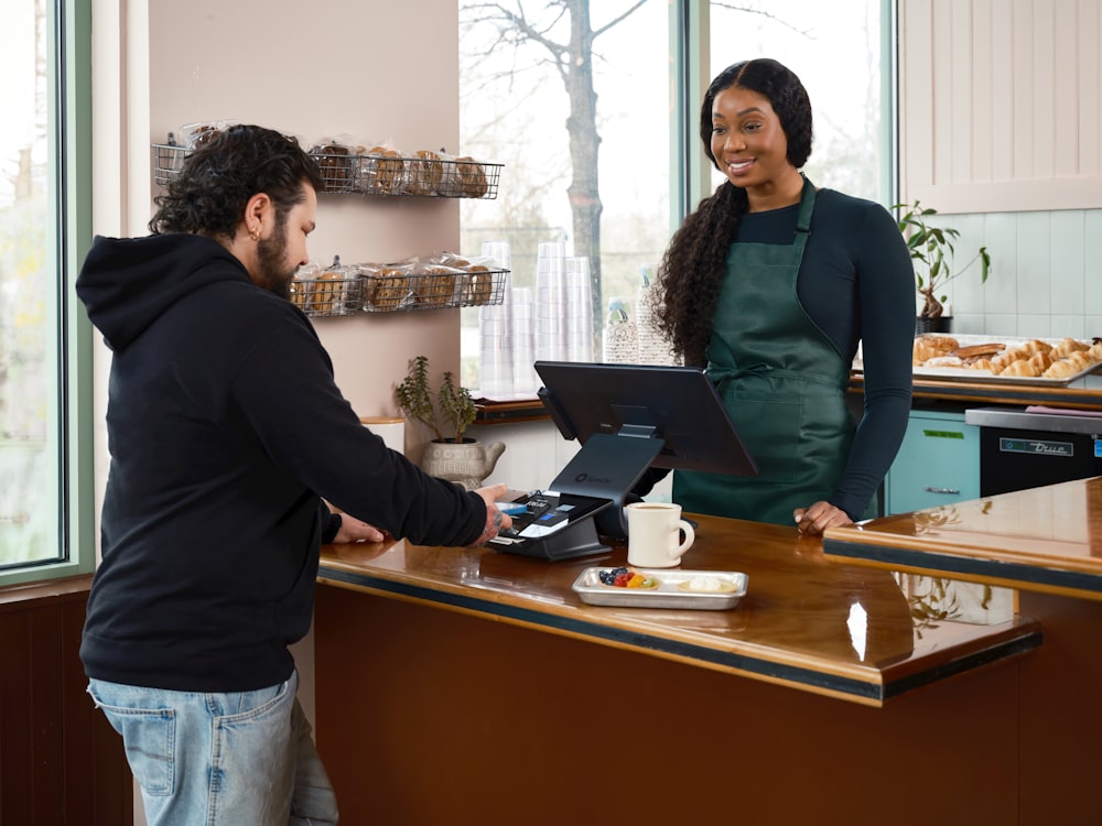 Lightspeed API and Custom Integrations for Restaurants 24 lightspeed api A man pays a smiling woman at a cafe counter.