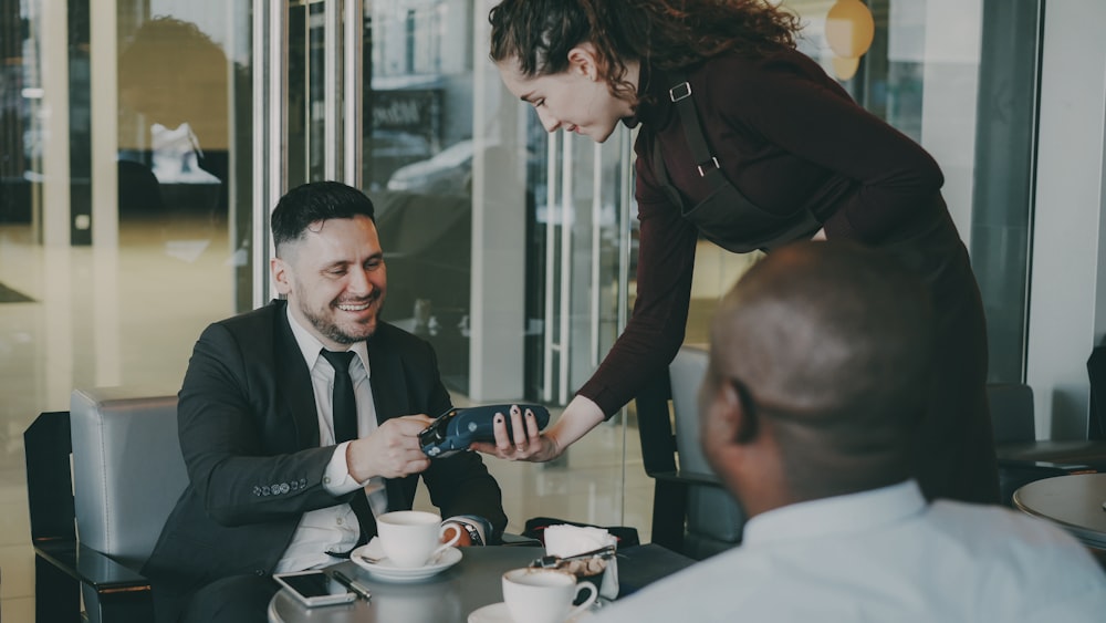 Toast Mobile App Development for Restaurants 25 Man pays with credit card at cafe table