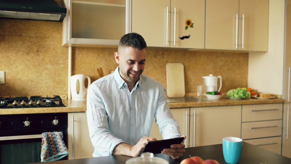 Lavu Analytics and Reporting for Restaurants 25 Man smiling while using a tablet in the kitchen.