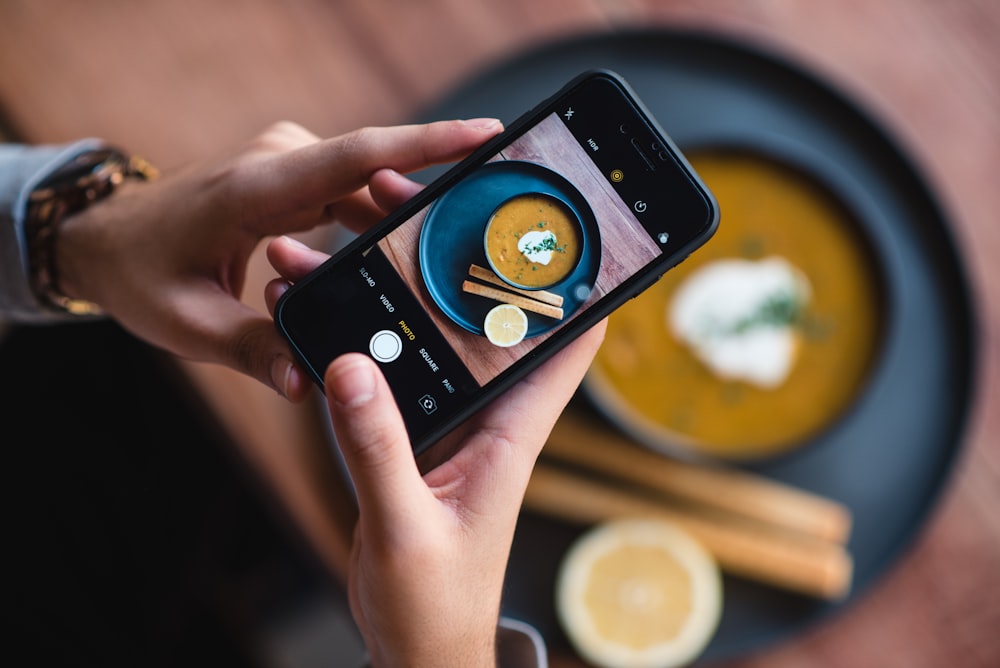 SpotOn Website Development for Restaurants 25 person holding black iphone 5 taking photo of moon