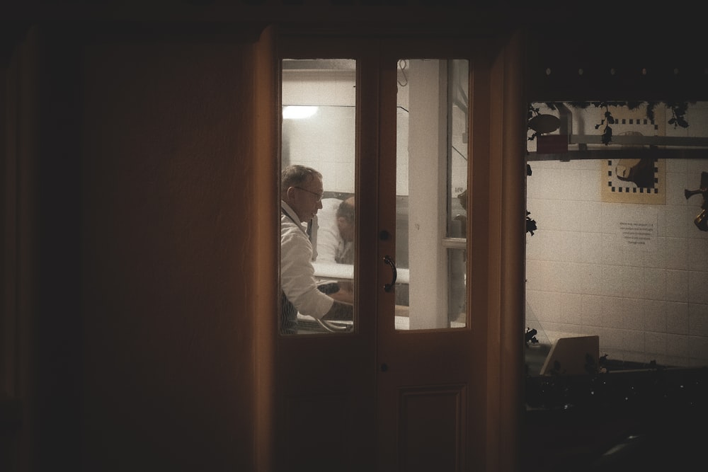 Square Mobile App Development for Restaurants 26 Man working in a dimly lit room through glass doors