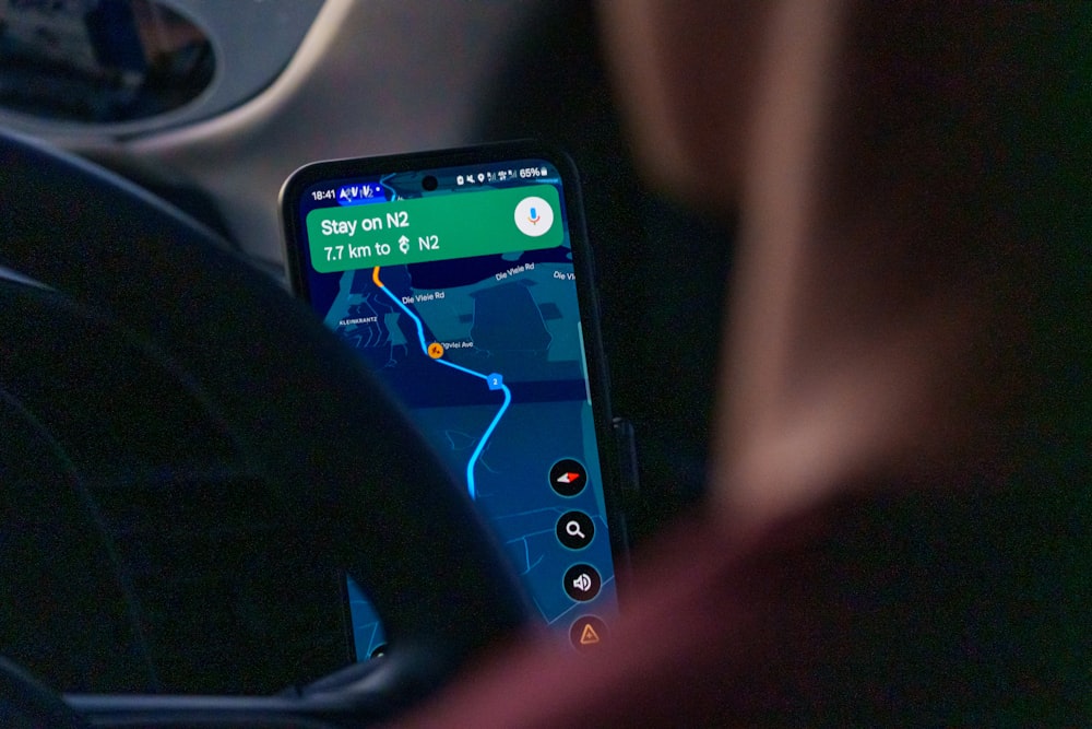 SpotOn API and Custom Integrations for Restaurants 26 Person using navigation app on smartphone inside car.