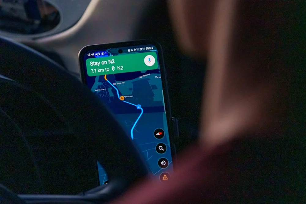 ezCater Preferred Caterer Person using navigation app on smartphone inside car.