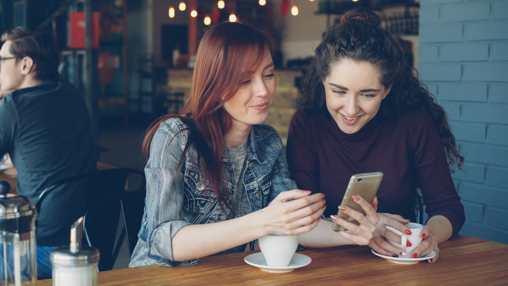 TouchBistro Loyalty and Rewards Setup for Restaurants 26 Two friends happily look at a phone together.